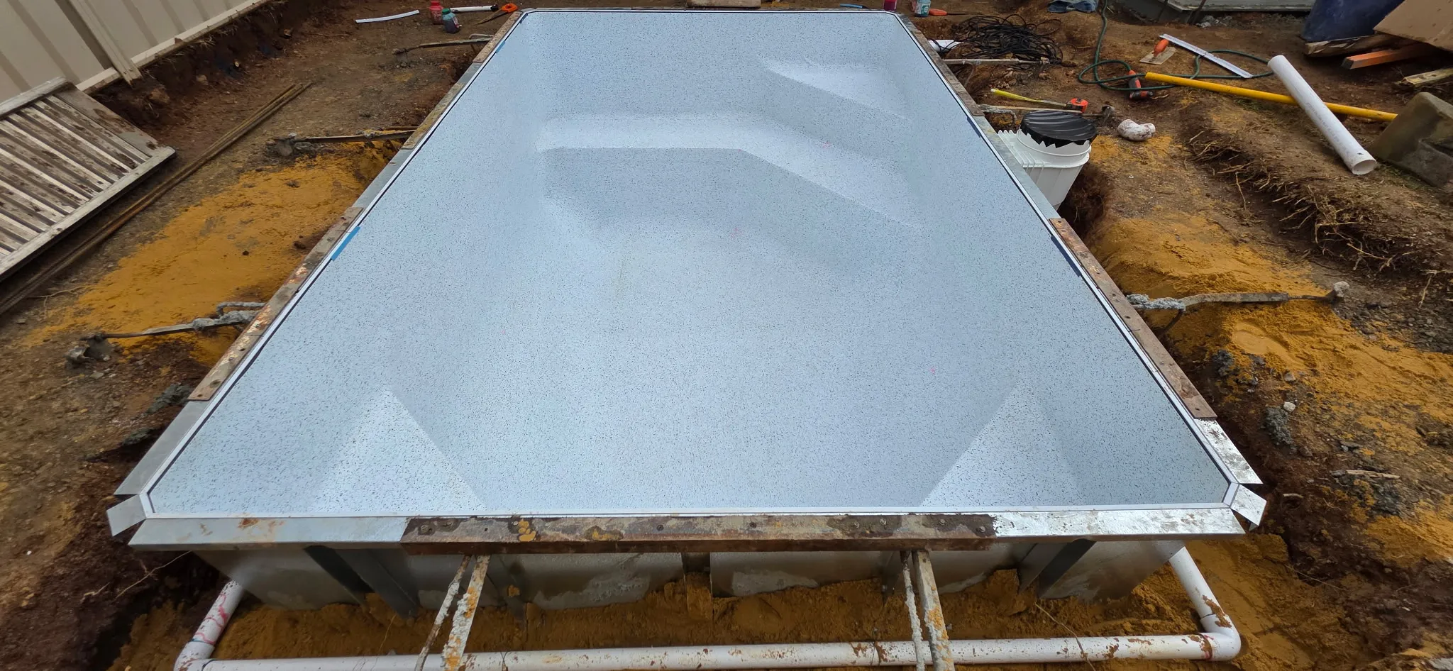 Lindeman vinyl liner installed in hybrid pool frame showing step entry and swimouts before water fill
