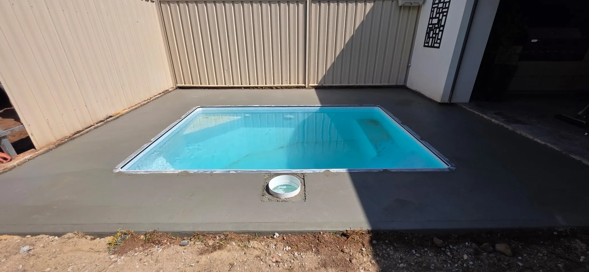 Finished concrete pad with recessed skimmer box and pool filled at Manningham plunge pool build