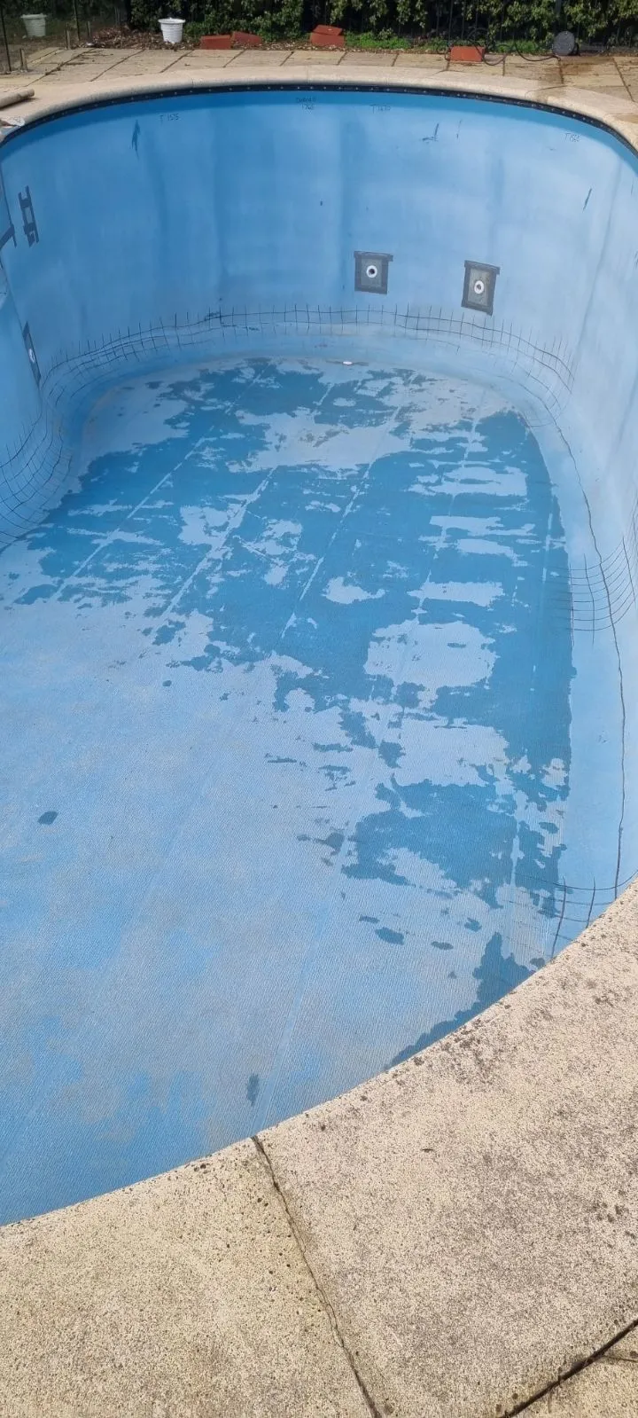 Deteriorated fibreglass pool shell at Crafers before renovation showing peeling surface and worn tile line at deep end
