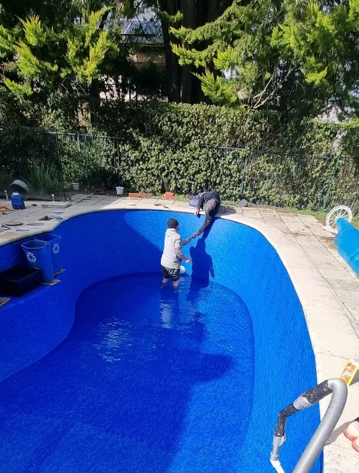 New vinyl liner being installed in kidney-shaped pool at Crafers with water filling in progress