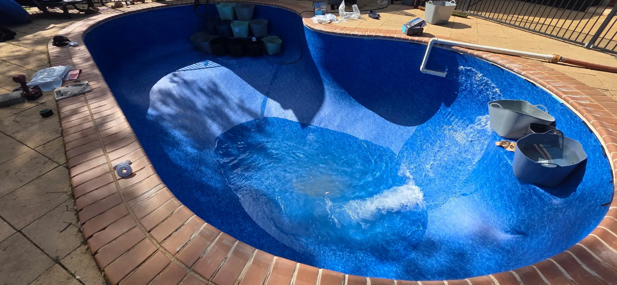 Water filling the renovated pool showing new Maui vinyl liner on step entry and bowled deep end at Coromandel Valley