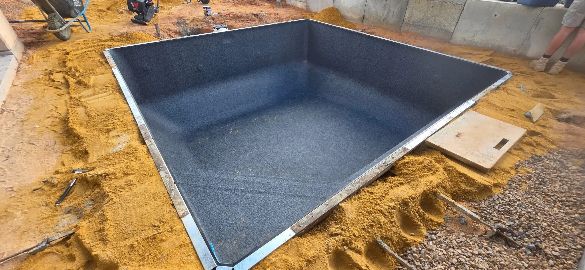 Installed Antique Black liner from corner angle showing pool fittings and sand base