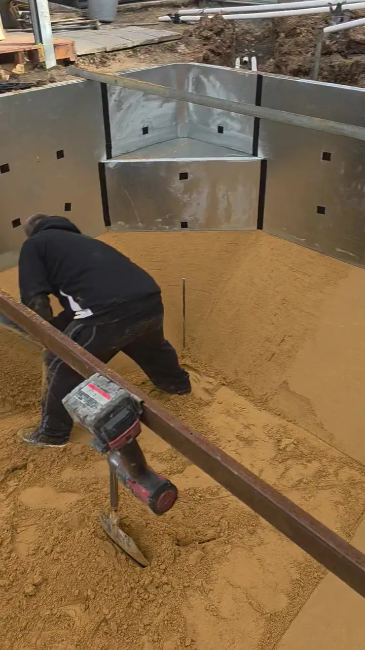 Sand base being levelled inside the steel pool shell at Woodcroft