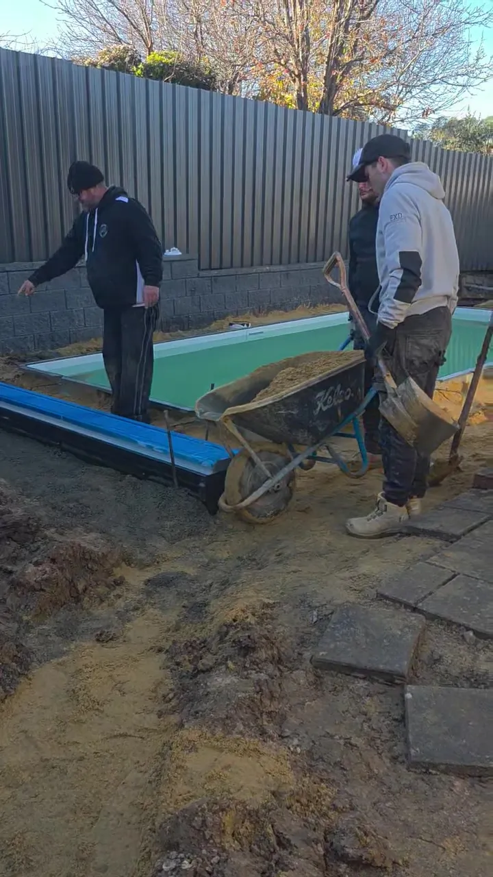 Concrete coping being screeded around the filled pool at Woodcroft