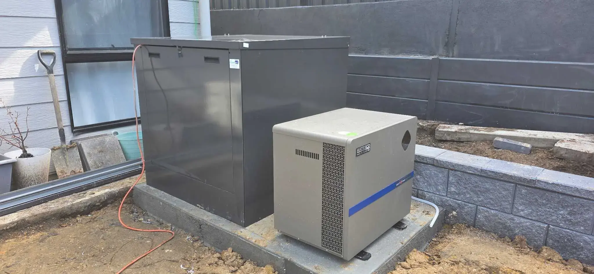 Outdoor pool equipment area with a pool heater and filtration system installed on a concrete pad